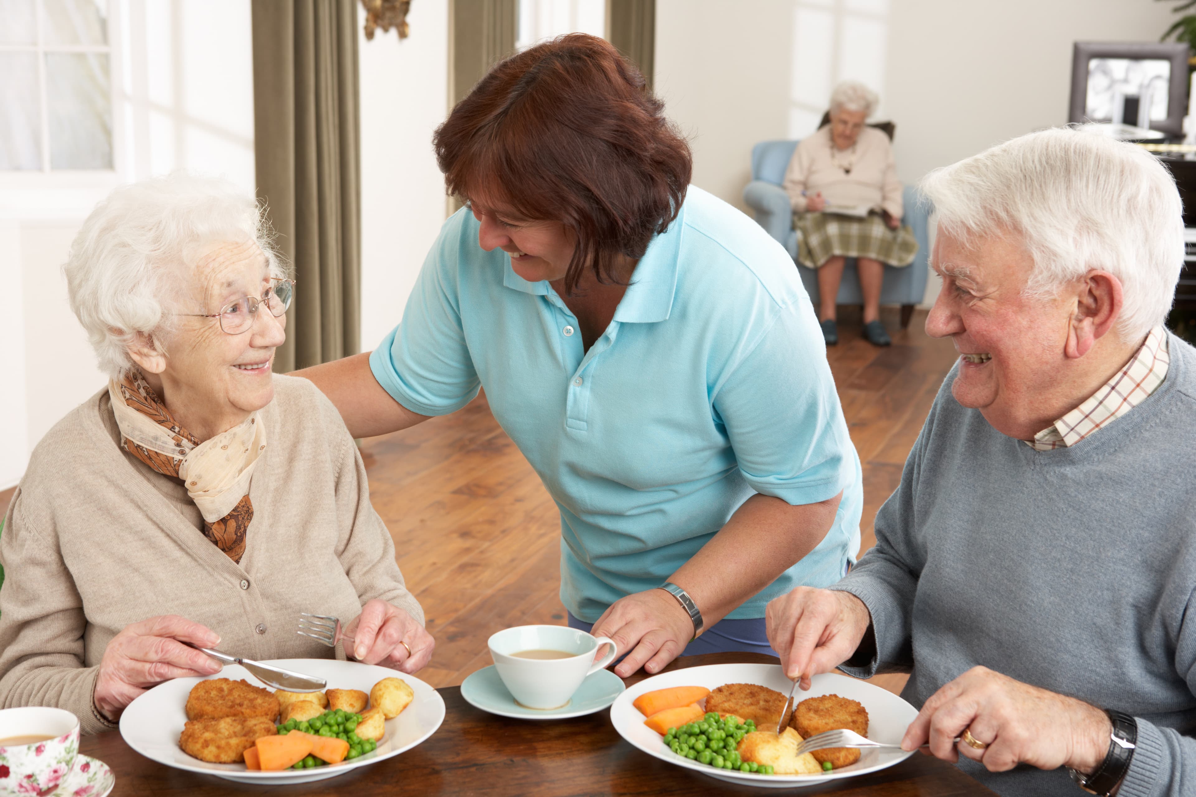 Mixed-race blended family eating dinner together at a kitchen table