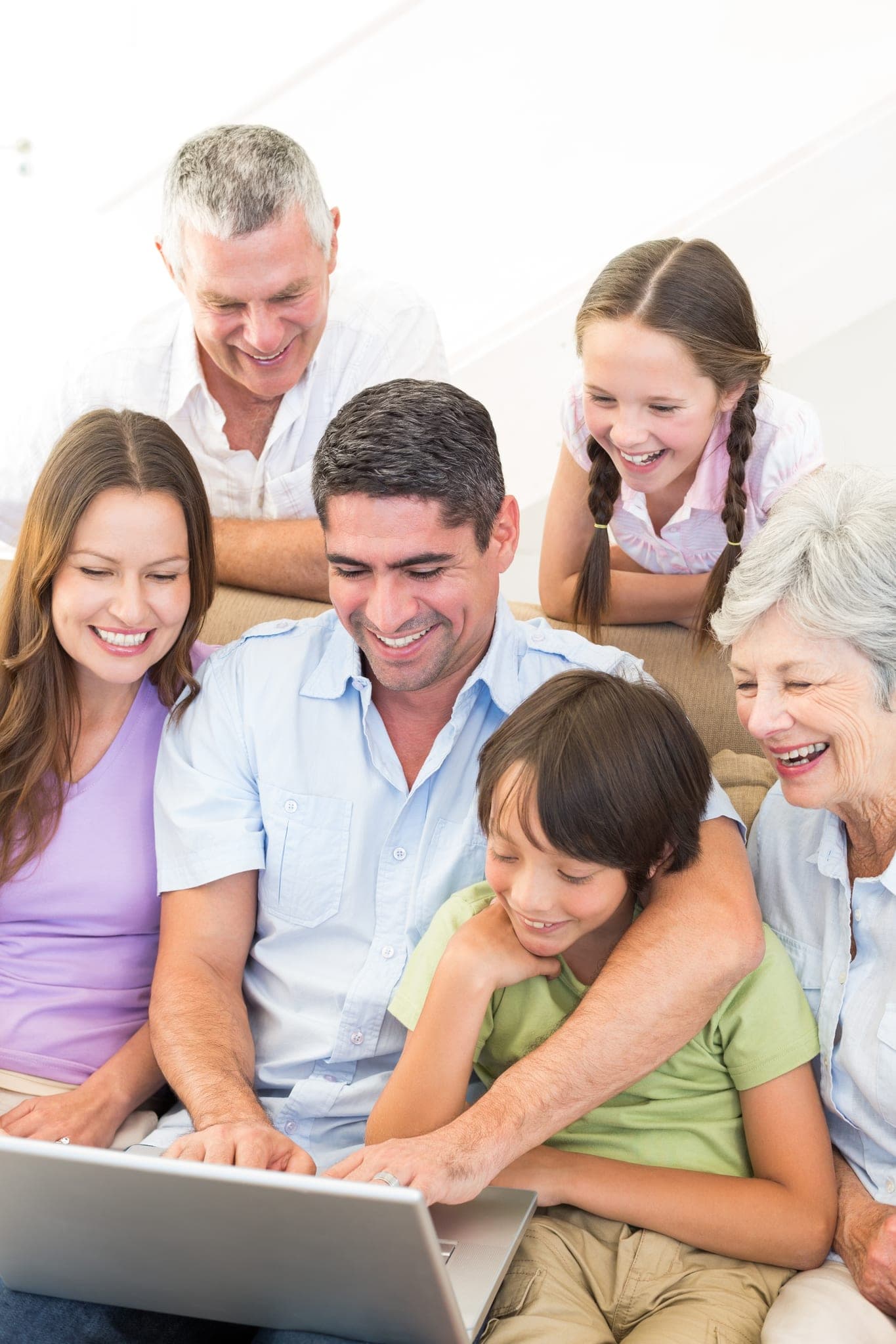 Family with children gathered around a laptop