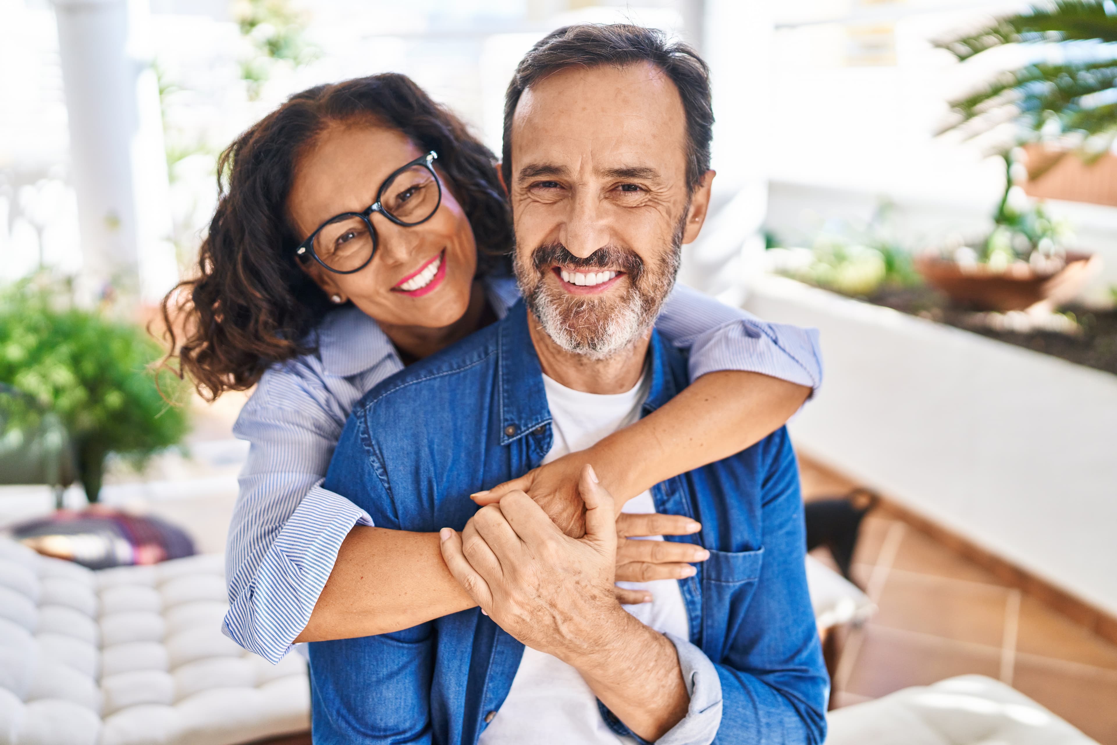 Happy middle-aged couple embracing and smiling outdoors